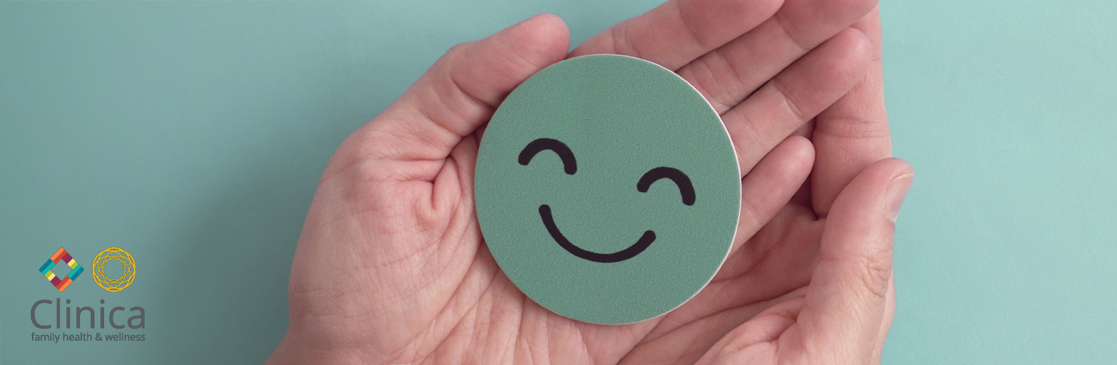 Clinican logo overlaying hands holding a green paper cut out of a smiley face