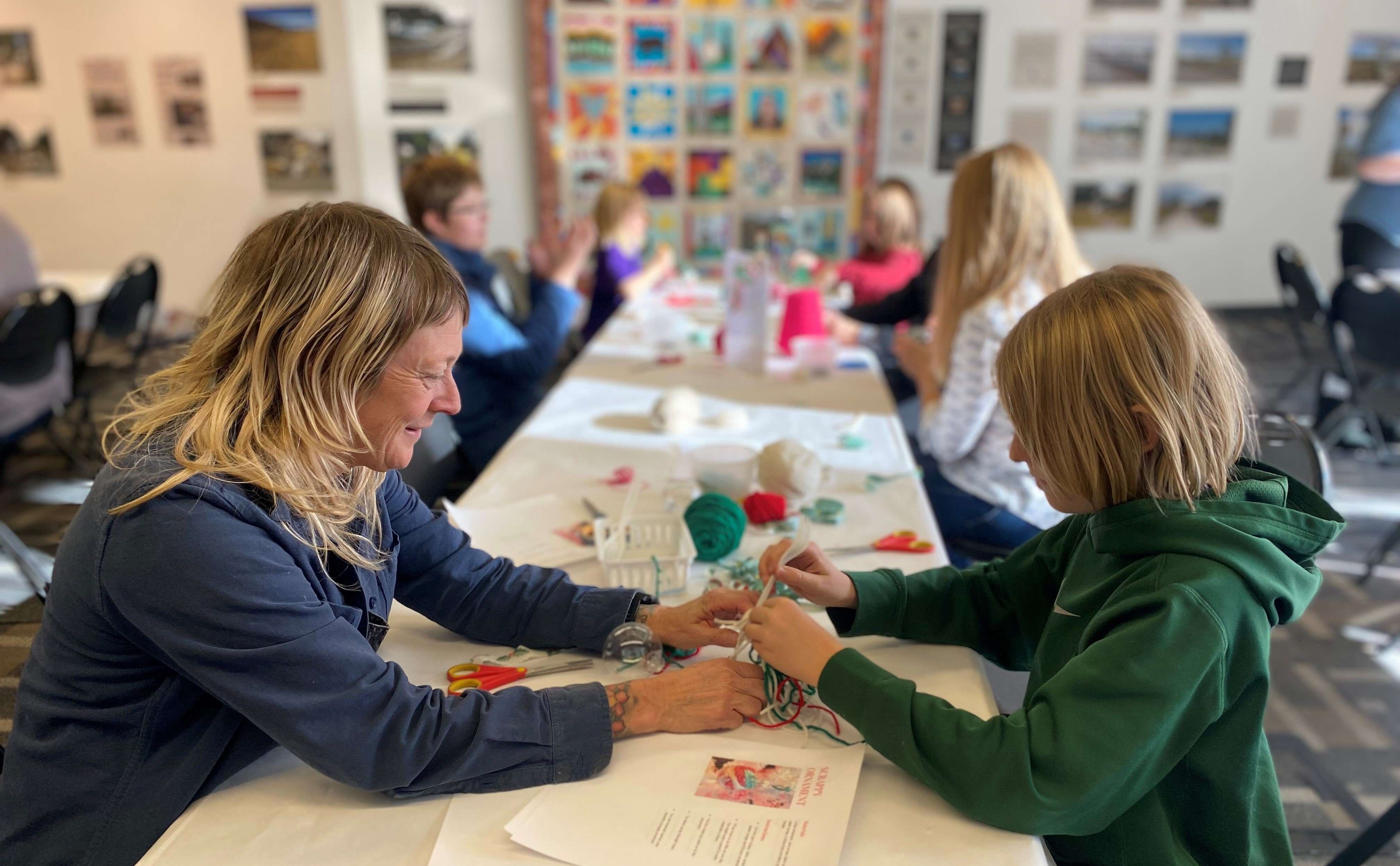 A woman and a child making ornaments together at a table
