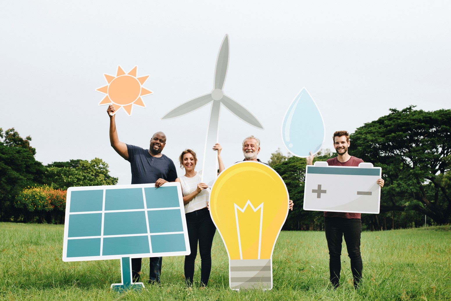 A group of people holding solar panel, light bulb, water drop, and batter signs