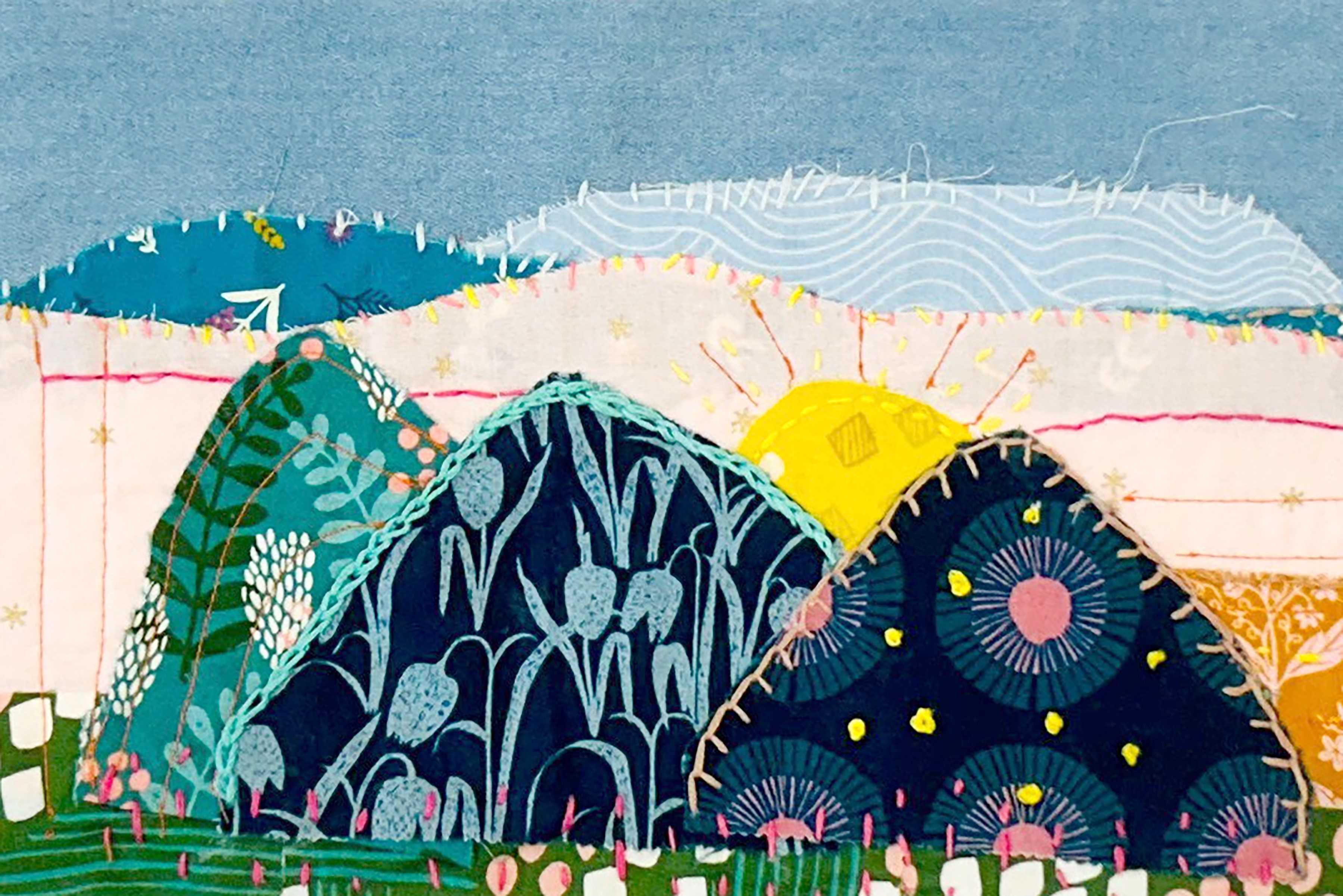 An applique sewing quilt featuring colorful mountains and a sun