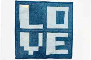 A blue and white quilt with the word LOVE