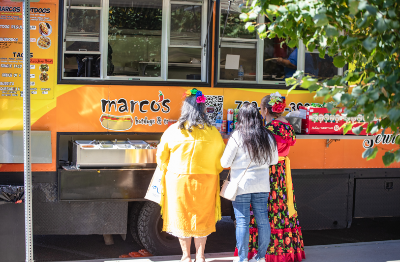 people in line at a food truck outside.