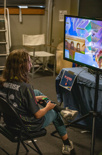 videogame tournament player sitting and playing brawlhalla