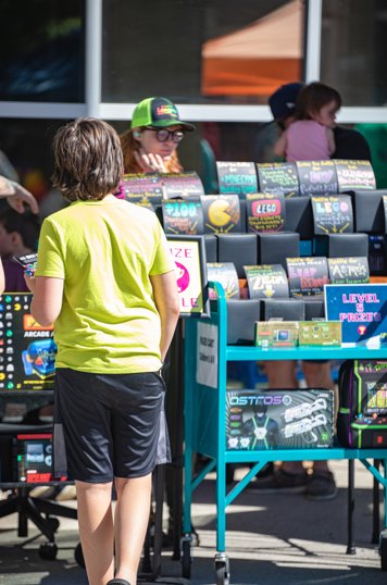 a table full of prizes and a boy looking at a prize at a festival