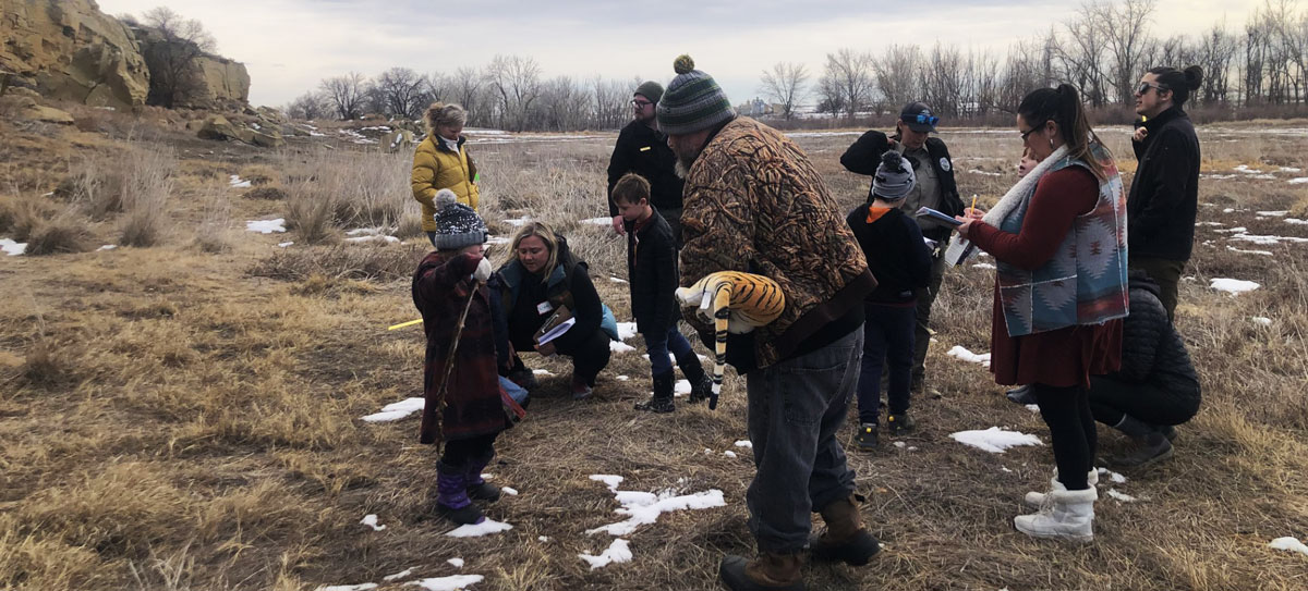 Rangers showing group evidence of animal tracks outdoors in nature area