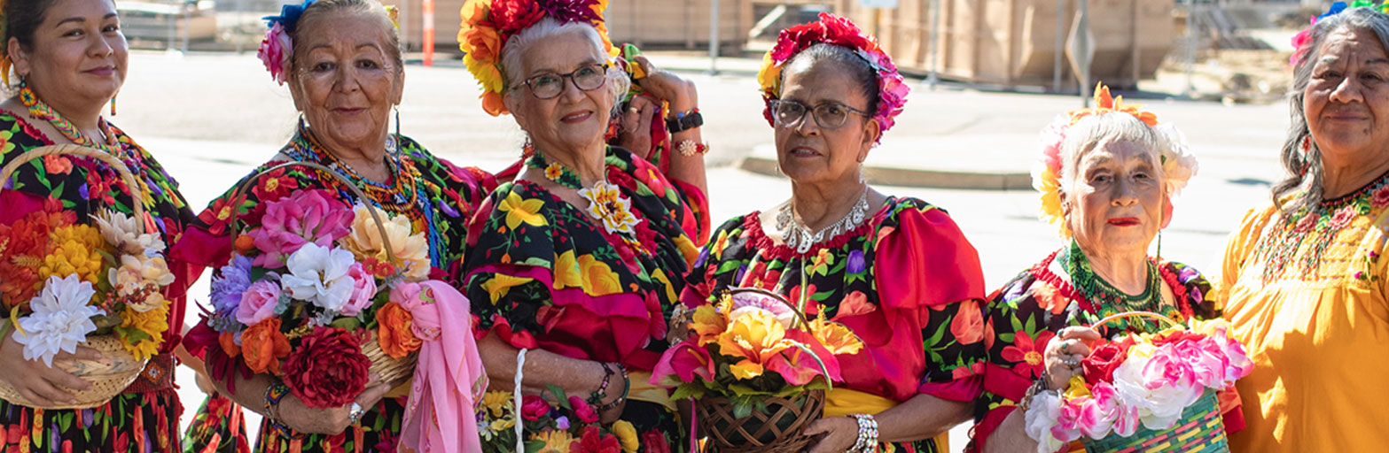 colorful flowery dresses and flowers worn by women in a line