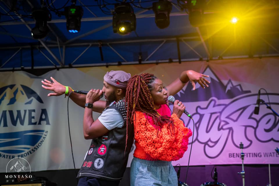 Members of The Reminders stand back to back performing on stage.