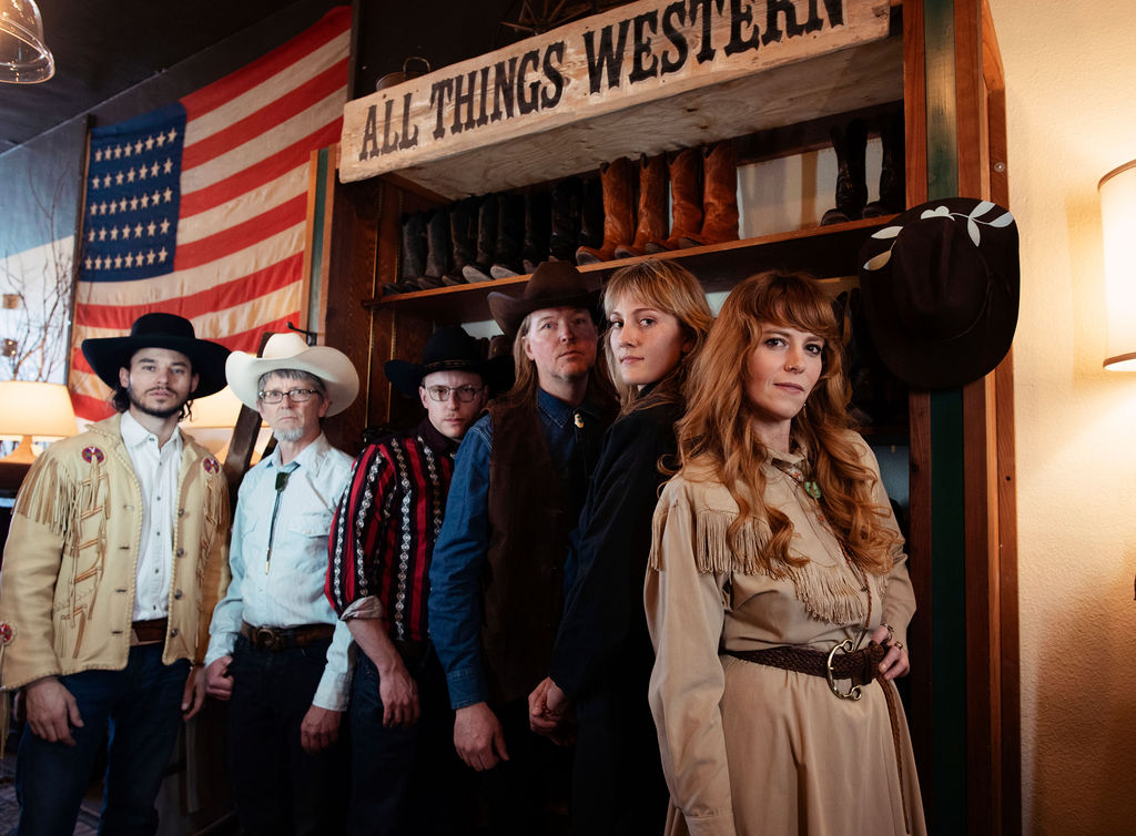 Members of Road Pony poses against a classic western background.