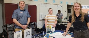 Photo of smiling Longmont Power & Communications employees sharing information at Longmont's 2026 Earth Day event. 