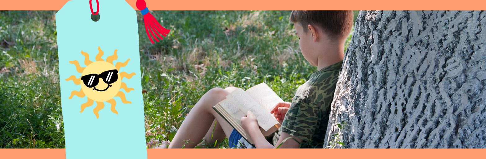 a Child reading a book and leaning against a tree in the grass.