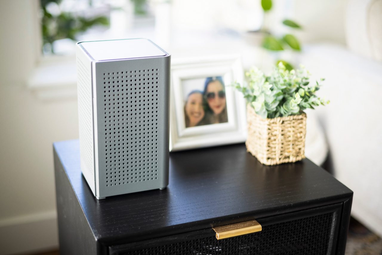Nextlight router sitting on a small end table with a photograph and plant nearby.