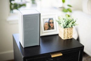 Nextlight router sitting on a small end table with a photograph and plant nearby.