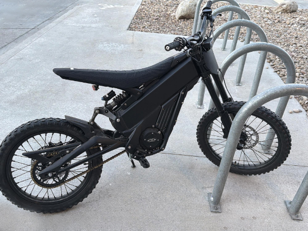 Black emoto parked in bike rack