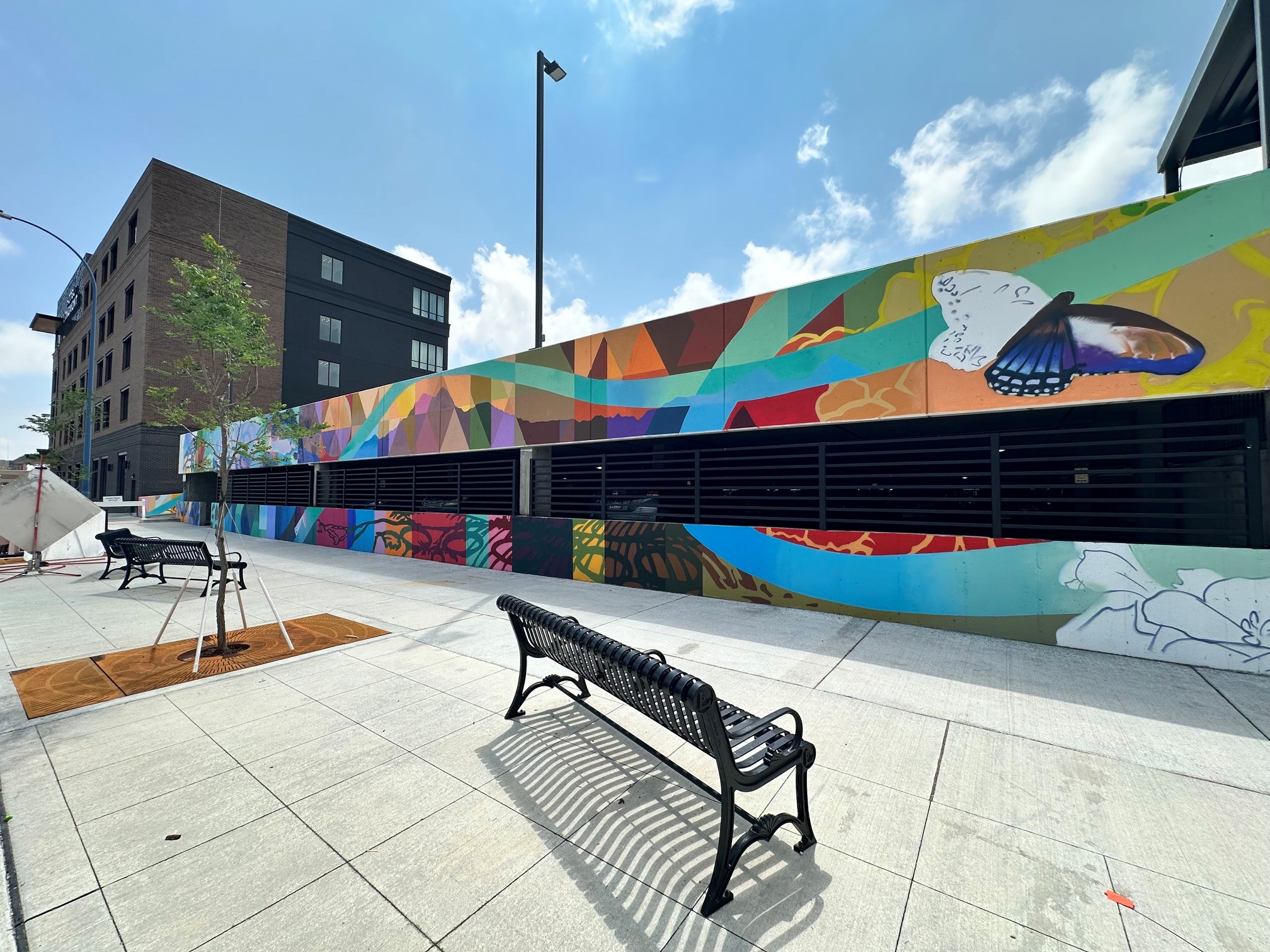 A colorful mural on the side of a parking deck outdoors