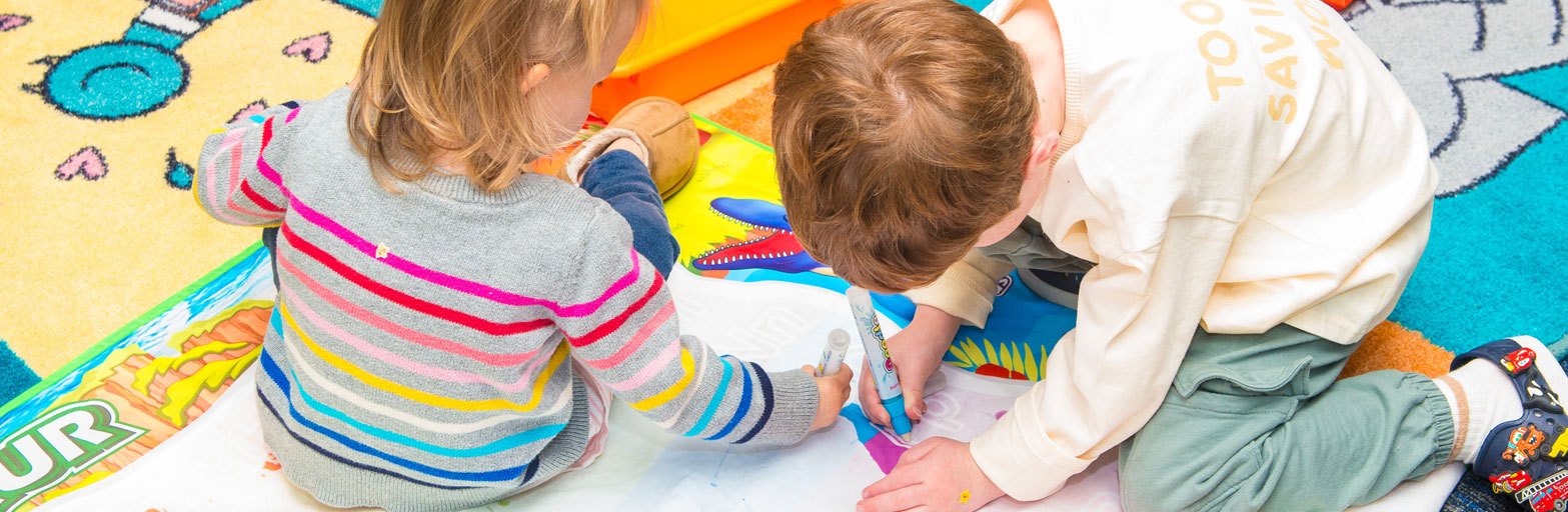 an indoor room and two children in a library storytime settling