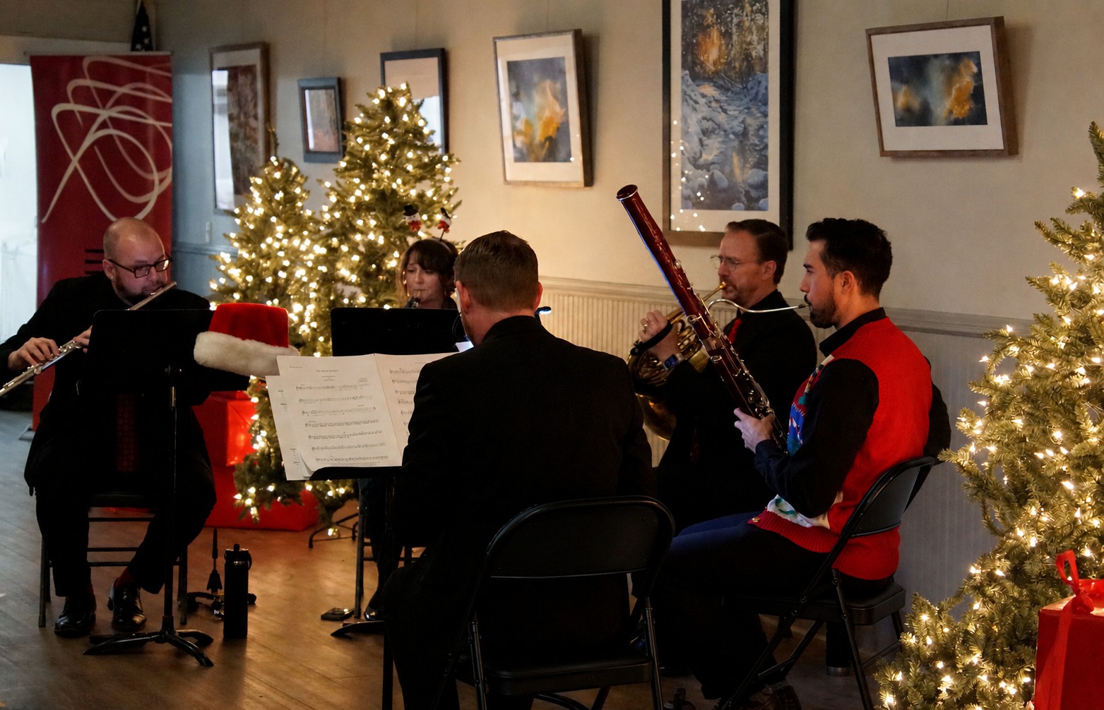 Festive photo of the Boulder Philharmonic Woodwind Quartet playing a holiday show.