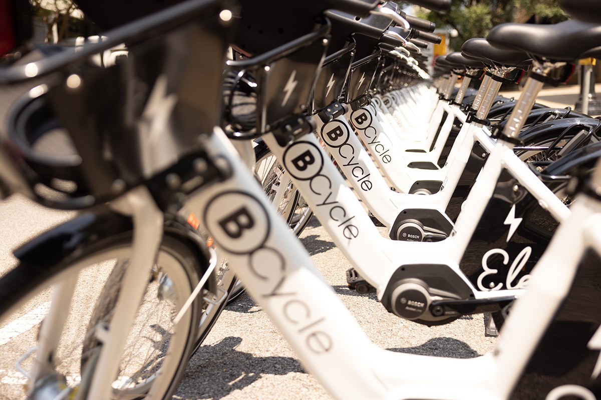 Looking down a row of white electric bicycles, each with "BCycle" on the frame.