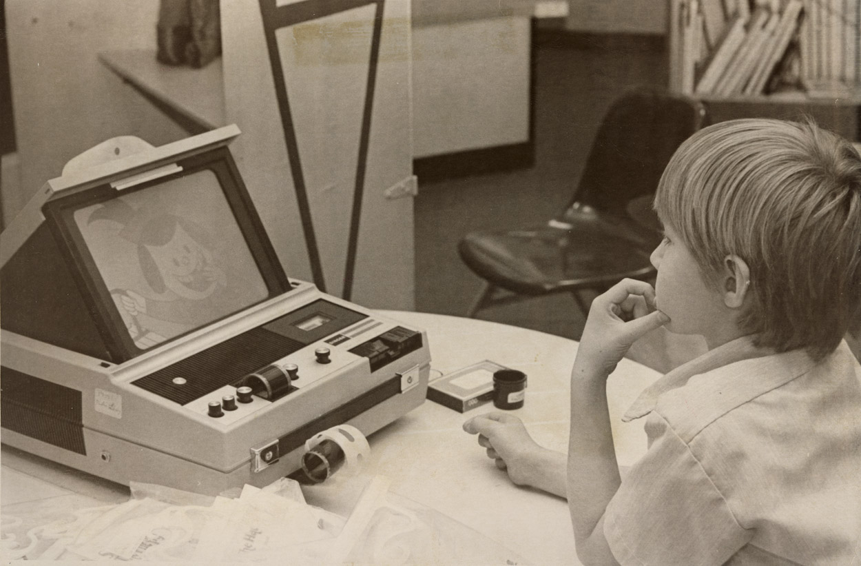 Black and white photo of Tony Olmedo watching a filmstrip at the Longmont Public Library. Published in the Times-Call on April 6, 1978.