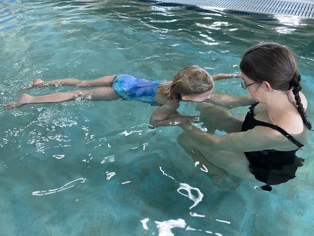 swim instructor in a pool with a young swimmer