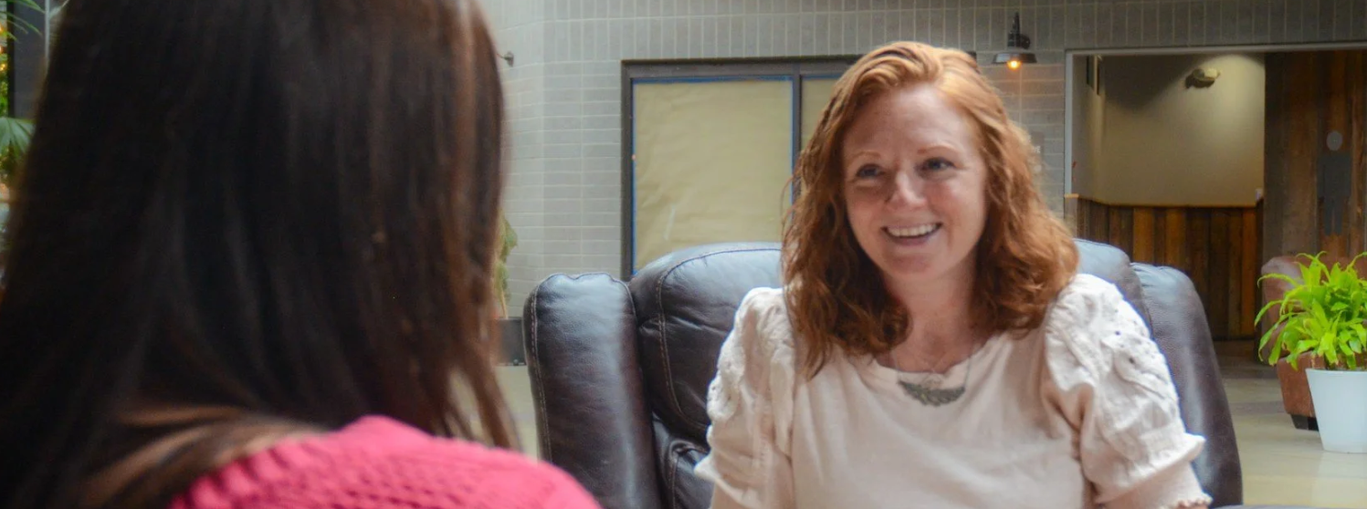 Career coach smiling talking with a client indoors.