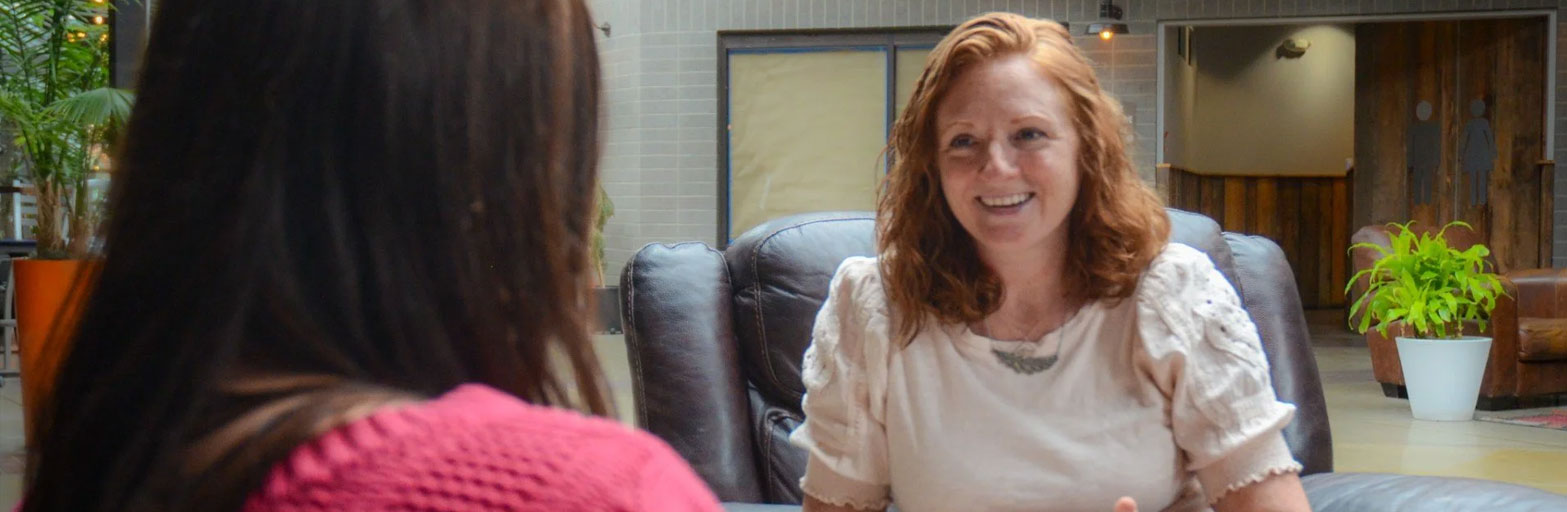 Career coach smiling talking with a client indoors.